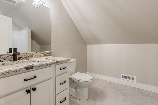 bathroom featuring vanity, toilet, and lofted ceiling