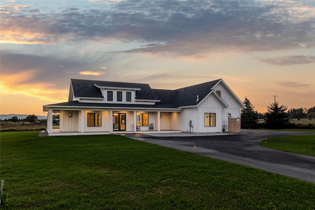 1052 Foxtail Dr, Kalispell, MT 59901 - back of property with board and batten siding, a lawn, a porch, and roof with shingles