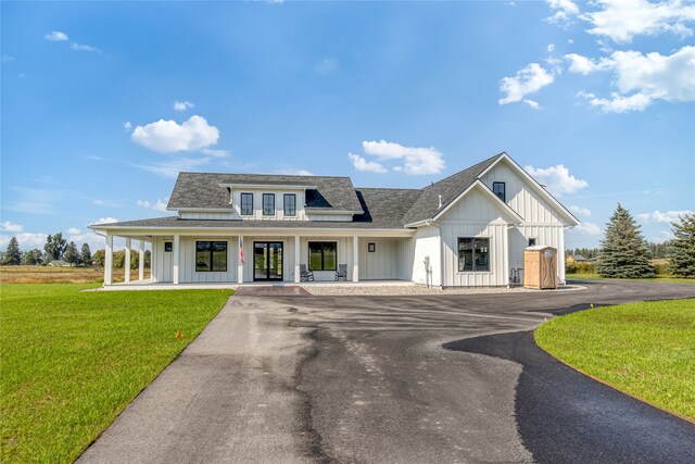 modern farmhouse with covered porch and a front yard