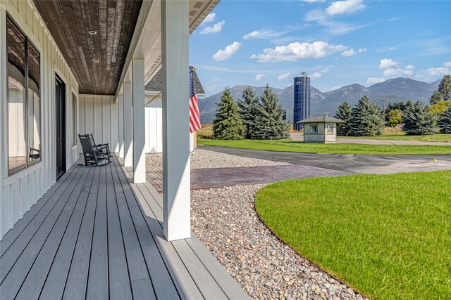 wooden deck featuring a yard and a mountain view