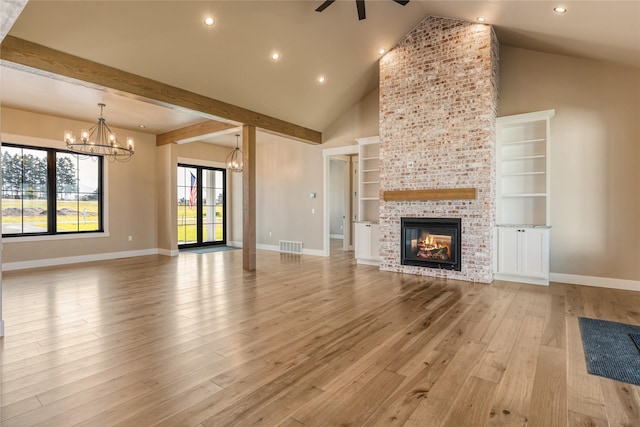 1052 Foxtail Dr, Kalispell, MT 59901 - unfurnished living room with ceiling fan with notable chandelier, baseboards, light wood-type flooring, and a multi sided fireplace