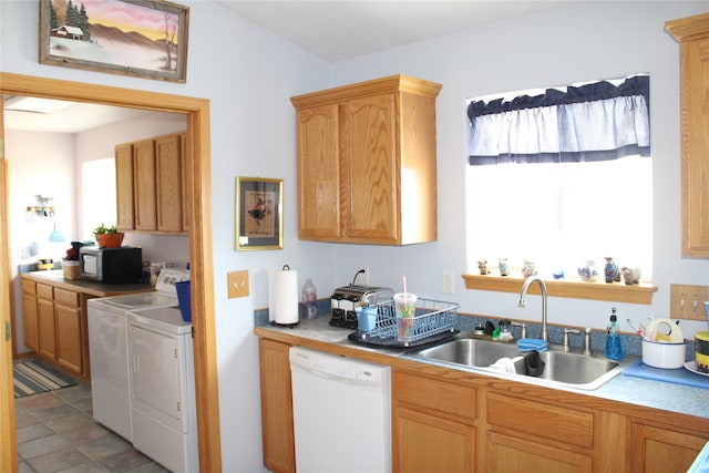 kitchen featuring tile flooring, sink, dishwasher, and washing machine and clothes dryer