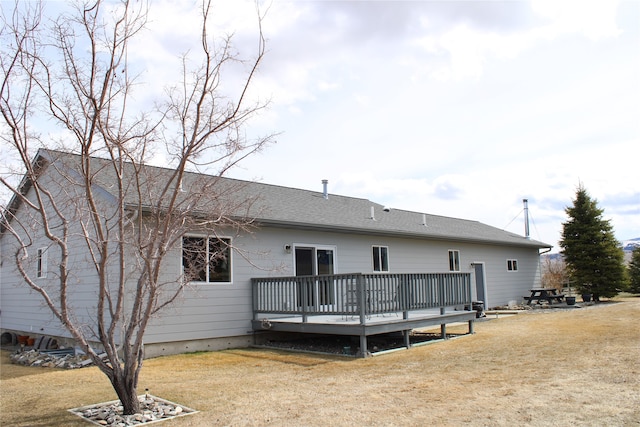 rear view of house with a deck and a lawn