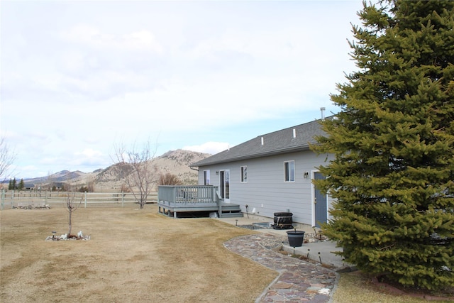 95 Furman Ln, East Helena, MT 59635 - back of house with a deck with mountain view, a patio area, and roof with shingles