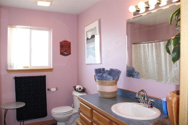 bathroom with vanity with extensive cabinet space and toilet