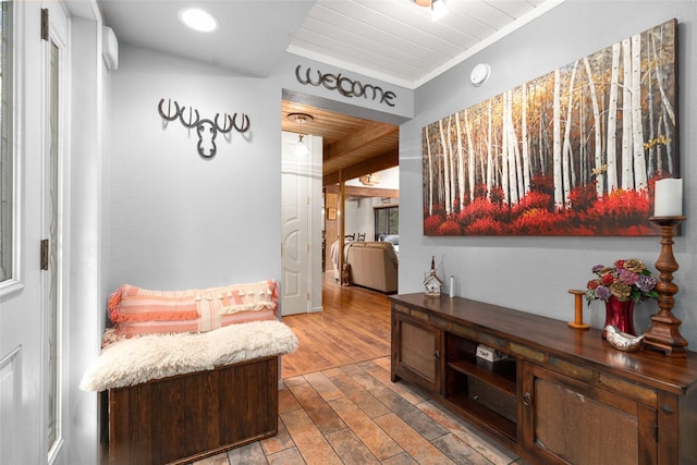 interior space with crown molding, light hardwood / wood-style floors, and wooden ceiling