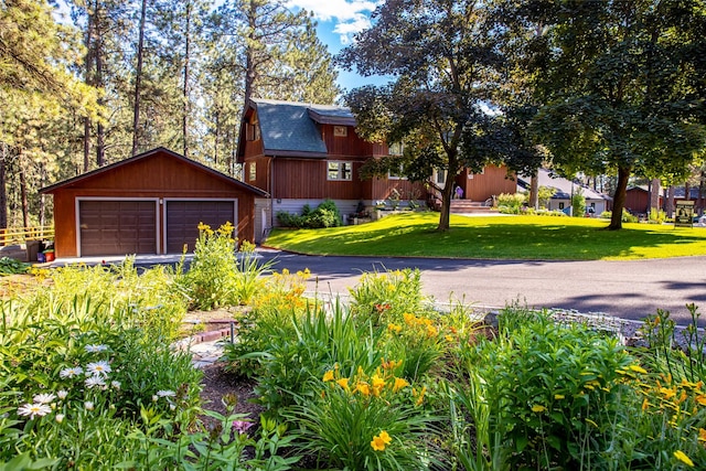 view of front facade featuring an outbuilding, a garage, and a front yard