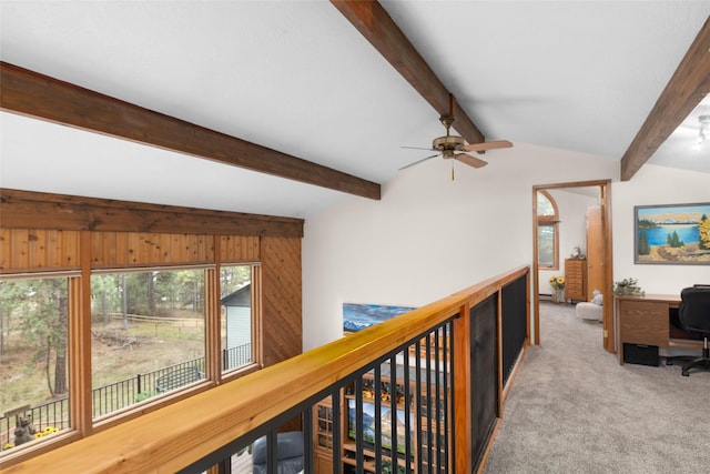 hall featuring vaulted ceiling with beams, light colored carpet, and wood walls