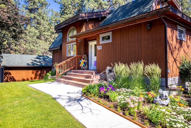 entrance to property featuring a lawn