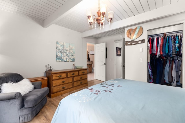 bedroom featuring beamed ceiling, hardwood / wood-style flooring, wood ceiling, an inviting chandelier, and a closet