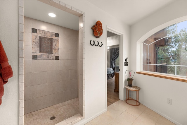 bathroom with a tile shower and tile patterned flooring