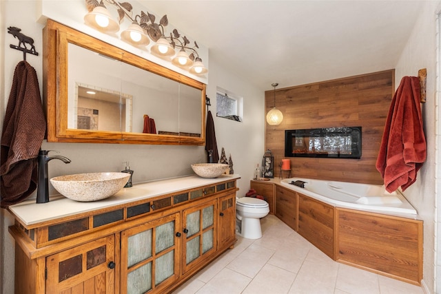 bathroom featuring wood walls, vanity, toilet, a bath, and tile patterned floors