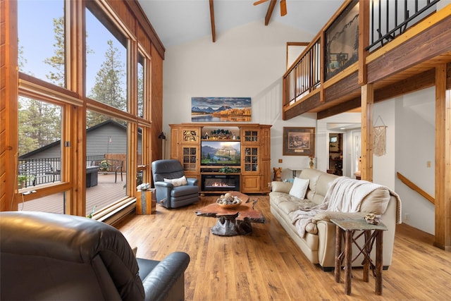 living room featuring beamed ceiling, light wood-type flooring, and high vaulted ceiling