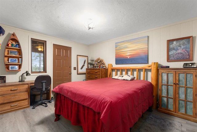 bedroom featuring light hardwood / wood-style floors and a textured ceiling