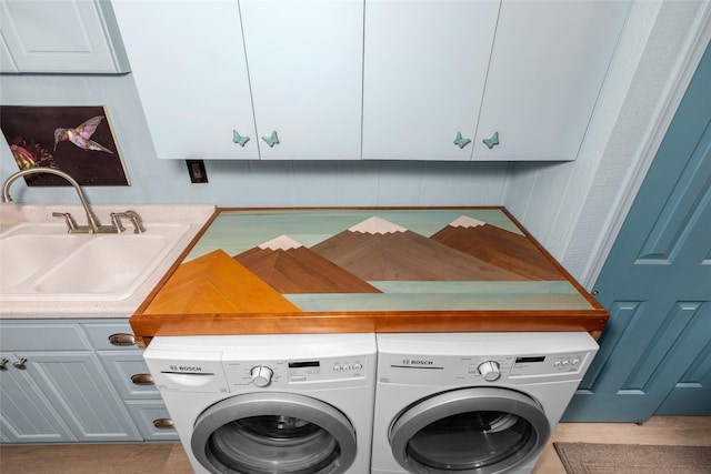 laundry room with cabinets, washing machine and dryer, and sink