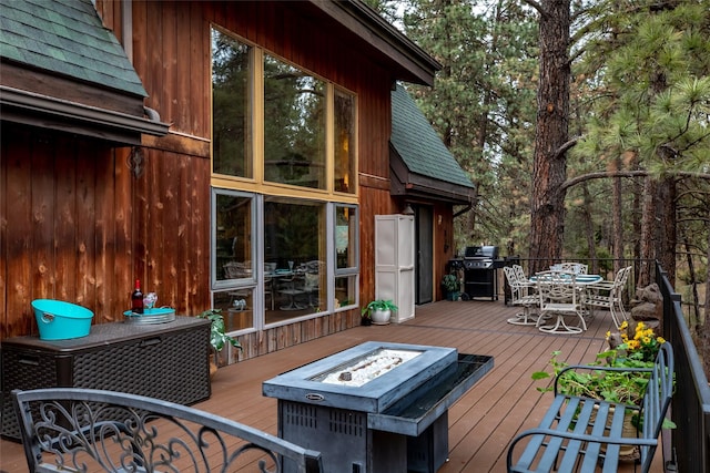 wooden deck with a grill and a fire pit