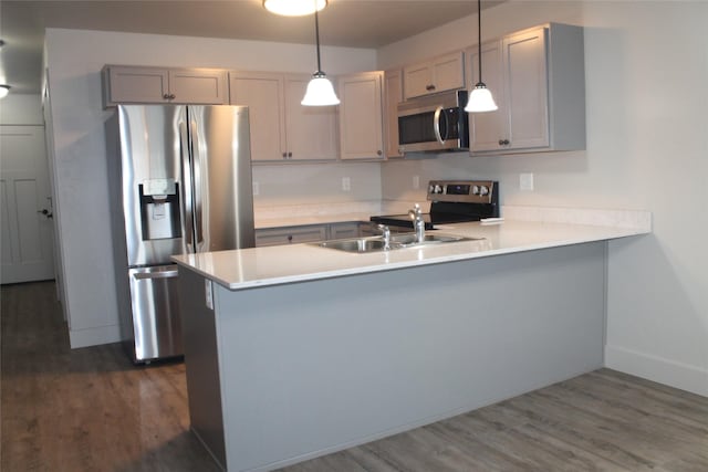 kitchen with pendant lighting, sink, kitchen peninsula, and stainless steel appliances