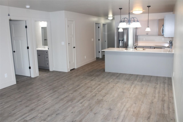 kitchen with stainless steel appliances, gray cabinetry, hardwood / wood-style floors, and pendant lighting