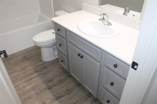 full bathroom with hardwood / wood-style floors, vanity, bathtub / shower combination, and toilet