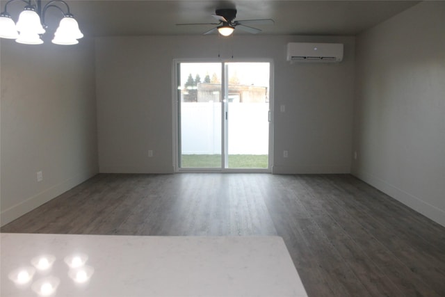 unfurnished room featuring a wall mounted air conditioner, ceiling fan with notable chandelier, and dark wood-type flooring