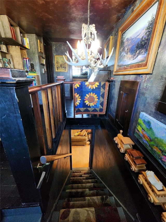 stairs featuring a chandelier