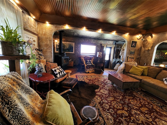 living room featuring wood ceiling, dark hardwood / wood-style floors, and a wood stove