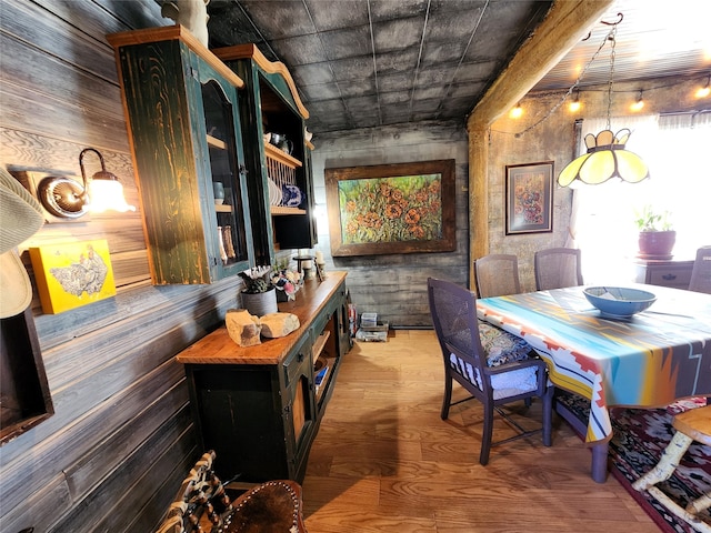 dining area with hardwood / wood-style flooring and wooden walls