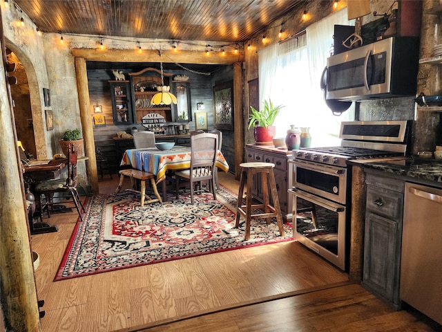 dining space featuring light wood-type flooring and wood ceiling