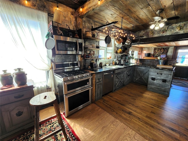 116 3rd Ave NE, Dutton, MT 59433 - kitchen featuring appliances with stainless steel finishes, dark wood-style floors, a wooden ceiling with exposed beams, dark countertops, and a ceiling fan