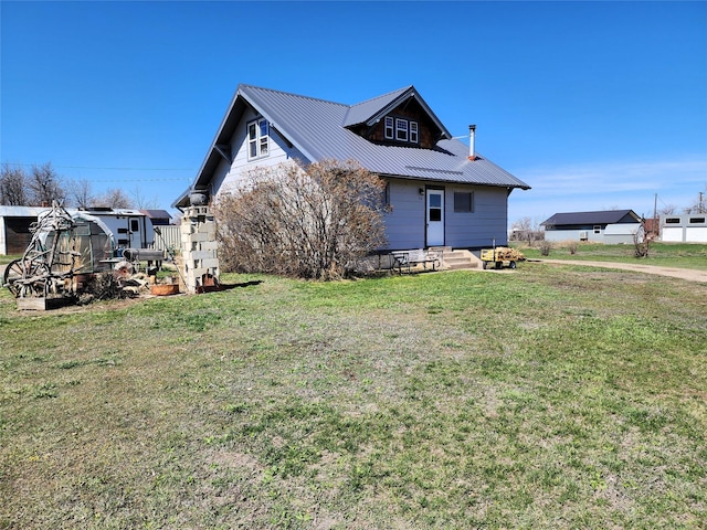 116 3rd Ave NE, Dutton, MT 59433 - view of side of property with entry steps, a lawn, a metal roof, and an outbuilding