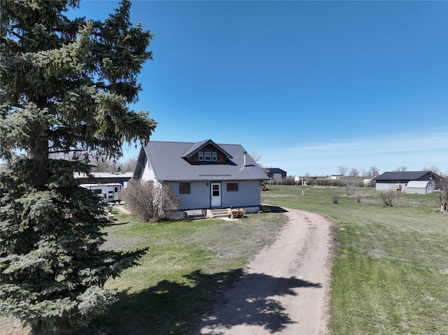 116 3rd Ave NE, Dutton, MT 59433 - view of side of home featuring a metal roof, dirt driveway, a yard, and entry steps