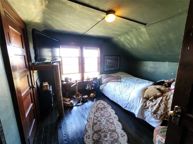 bedroom with a textured ceiling, ceiling fan, dark hardwood / wood-style floors, and vaulted ceiling