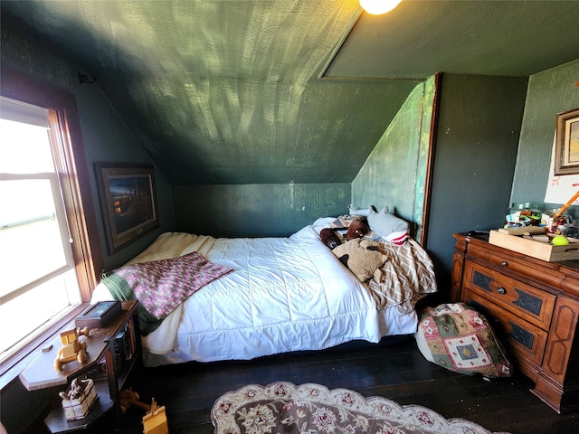 bedroom with wood-type flooring and vaulted ceiling