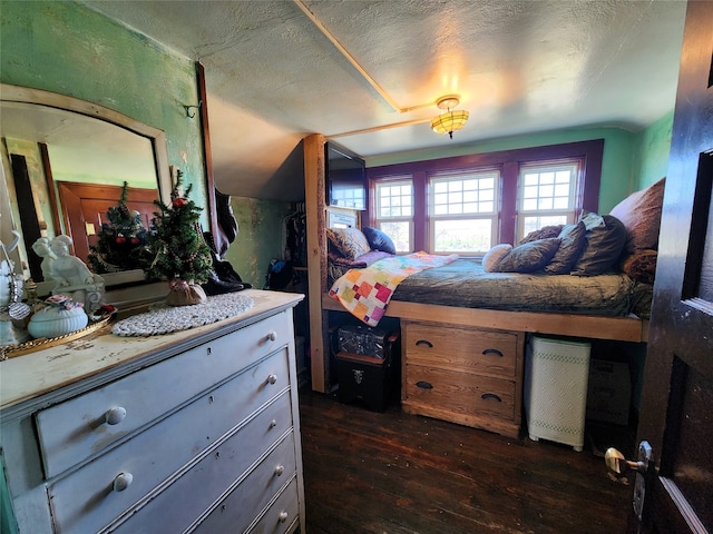 bedroom with dark hardwood / wood-style flooring and a textured ceiling