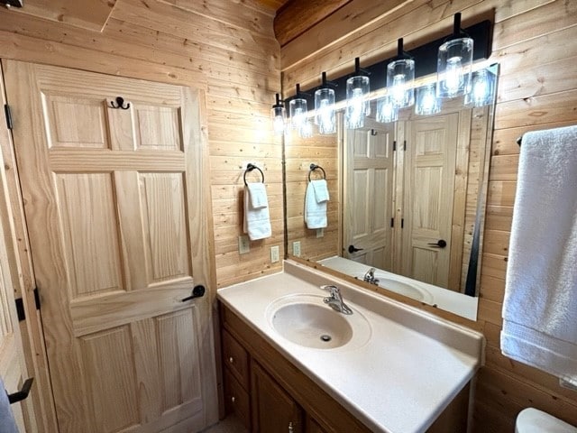 bathroom with vanity and wooden walls