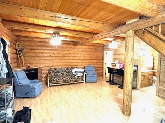 interior space with beamed ceiling, wood-type flooring, rustic walls, and wooden ceiling