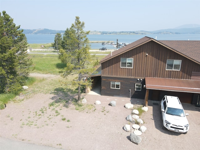 view of side of property featuring a water and mountain view and a garage