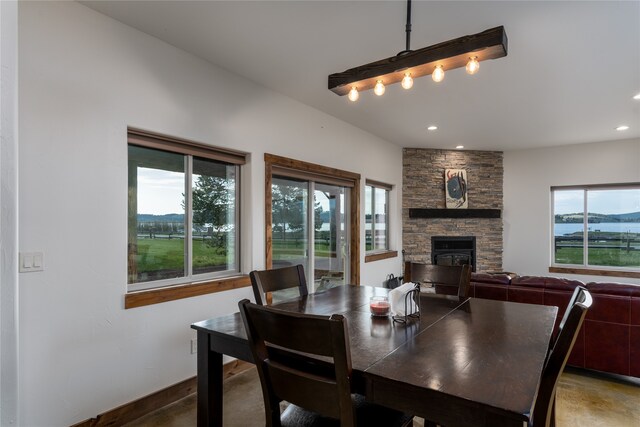 dining area with a fireplace and a water view