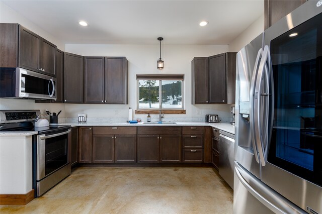 kitchen with dark brown cabinetry, sink, stainless steel appliances, and pendant lighting