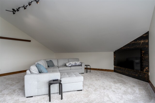 living room with carpet flooring, track lighting, and lofted ceiling