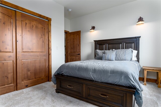 bedroom featuring light colored carpet and a closet