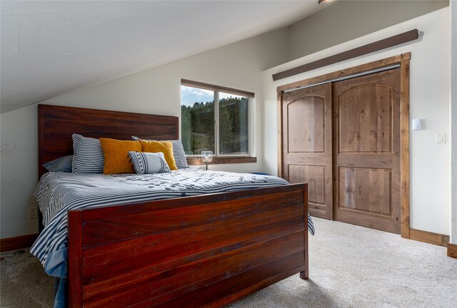 bedroom with carpet, a closet, and vaulted ceiling