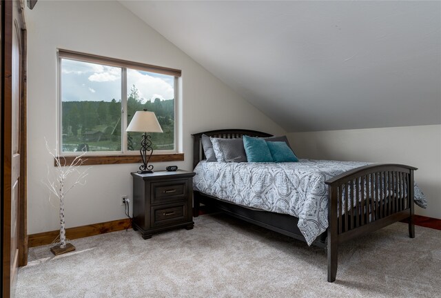 bedroom with light carpet and vaulted ceiling