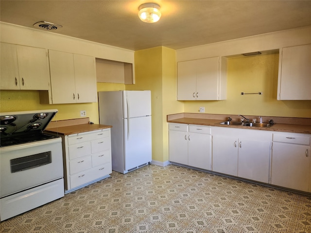 kitchen with white appliances, sink, and white cabinets