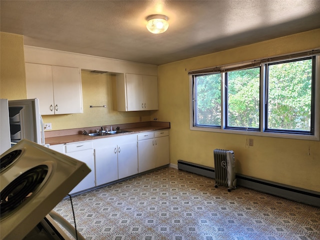 kitchen with white range, sink, a textured ceiling, and white cabinetry