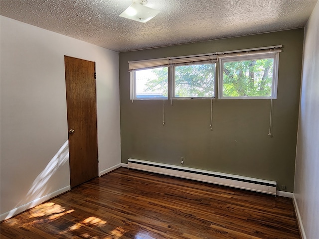 empty room with a baseboard radiator, dark hardwood / wood-style floors, a textured ceiling, and a healthy amount of sunlight