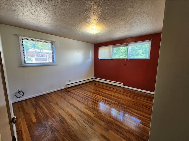 spare room with wood-type flooring, a wealth of natural light, and a textured ceiling