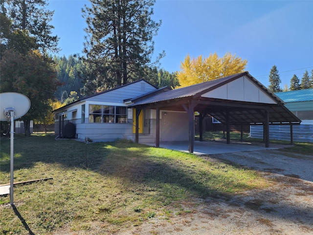 view of home's exterior with a carport and a yard