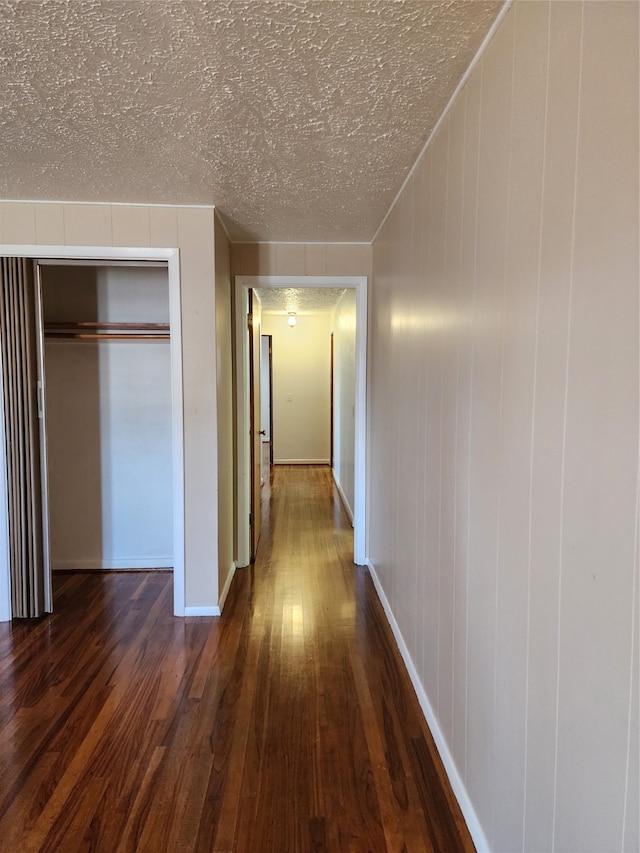 corridor featuring dark hardwood / wood-style floors and a textured ceiling