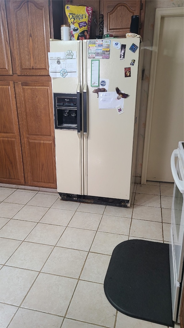 kitchen featuring light tile patterned floors and white fridge with ice dispenser